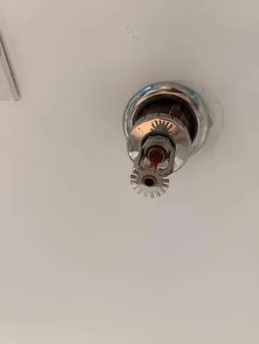 Rociador colgante con roseta instalado en cielo falso de local comercial